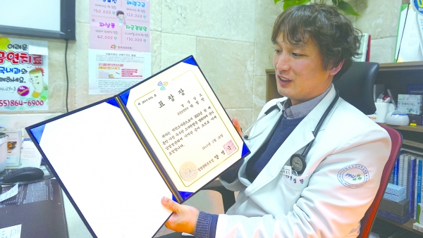 기자의 요청에 의해 ‘질병관리본부에서 받은 표창장’을 보여주는 박정민 원장