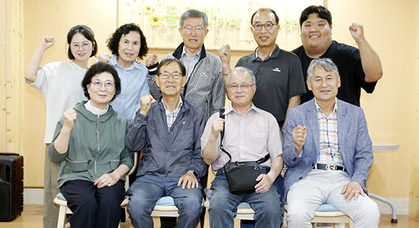 선암회가 운영하는 복지관 내 들국화 카페에서 복지관 관계자와 선암회 임원들이 함께 인터뷰를 하고 단체사진을 찍고 있다