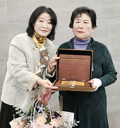 김희란(왼쪽) 남해여중 교장이 최문자 동문에게 감사패를 전달하고 있다