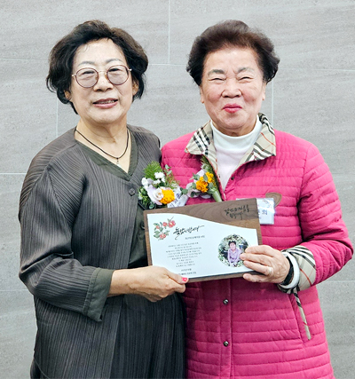 김화춘(왼쪽) 회장이 최근희 동문에게 공로패를 전달하고 있다