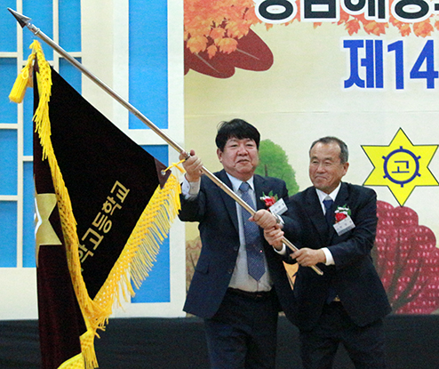 최현철(왼쪽) 신임회장과 박정삼 이임회장이 함께 회기를 흔들고 있다