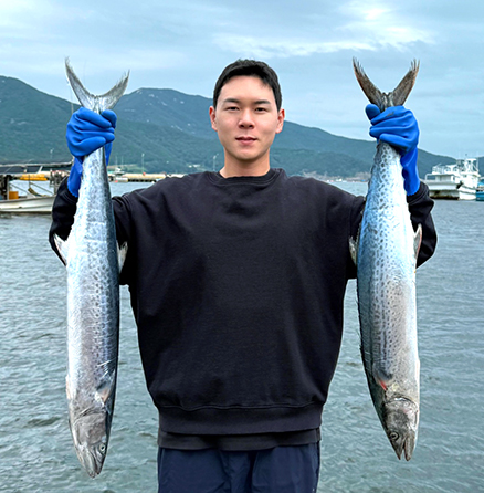 가두리양식장에서 양손에 삼치를 들고 있는 박현석 대표
